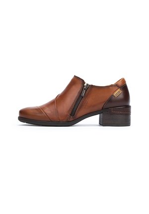 Botas de tobillo de cuero marrón con un tacón bajo tipo bloque, cremallera lateral, costuras curvas y una textura suave. Presenta un acento de tacón en un tono más oscuro.