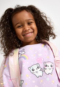 Lila Sweatshirt mit verspielten Kätzchen-Designs, verziert mit Regenbögen und Herzen. Kind trägt einen glänzenden, hellrosa Rucksack über einer Schulter.