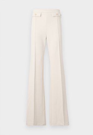 High-waist cream trousers with wide legs, front seam detail, and flap pockets with buttons on the waistband.