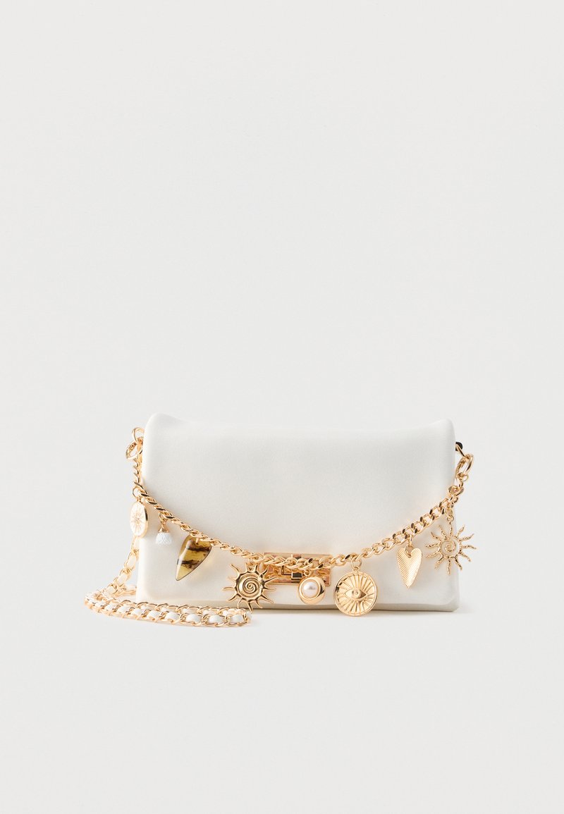 Pochette rectangulaire blanche avec bandoulière en chaîne dorée et breloques décoratives dorées comprenant un soleil, un cœur, un œil et une perle sur un fond uni.