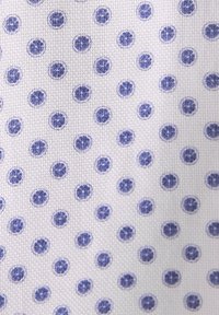 Tessuto di cotone con sfondo bianco, caratterizzato da un motivo ripetuto di piccoli cerchi blu con disegni floreali.