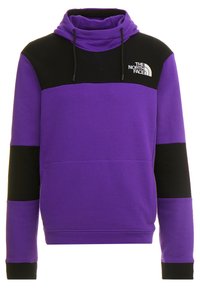 Lila och svart sweatshirt med hög krage, långa ärmar, framficka och dragsko; har kontrasterande färgblock och logotyp.