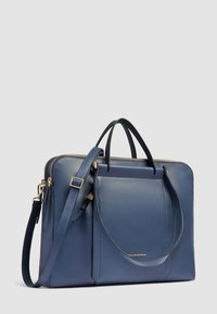 Blauwe leren handtas met dubbele bovenhandvatten en een afneembare schouderriem. Voorzien van een ritssluiting en een voorvak. Gladde textuur.