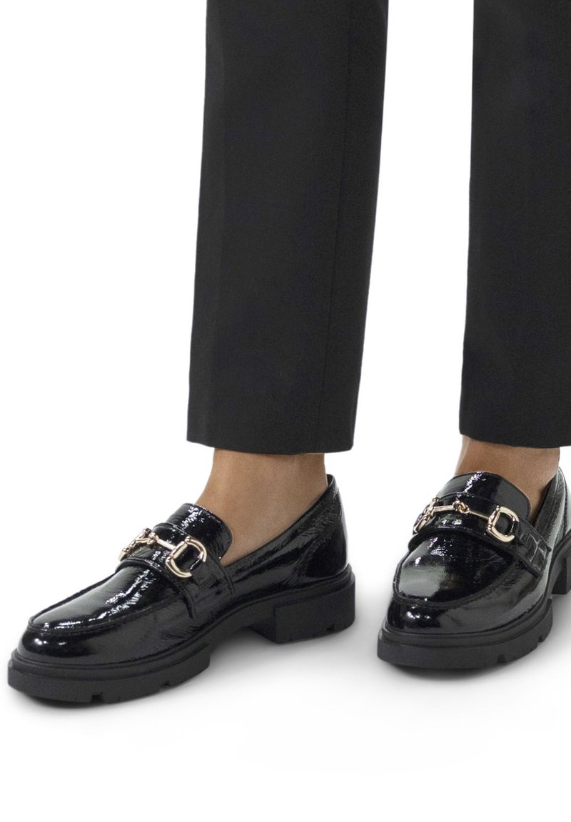 Mocassins en cuir verni noir avec une semelle épaisse et des accents en métal doré. Présente une finition lisse et brillante ainsi qu'une silhouette classique.