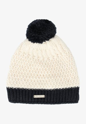 Strikket hue i creme og marineblå, med en tekstureret krop, ribbet marineblå manchet og en fluffy marineblå pom-pom på toppen. Metalllogo detaljer inkluderet.