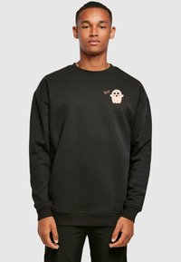 Musthave mustikas värvi dressipluus ümarate kraega, millel on roosa kummitusgraafika ja "Boo!" tekst vasakul rinnal. Pehme ja tekstureeritud kangas.