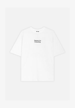 T-shirt blanc à manches courtes avec l'inscription « Humans Are Exhausting. » imprimée en noir, centrée sur la poitrine.