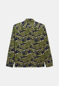 Chemise à manches longues avec un motif de camouflage vert et marine, fabriquée en tissu doux, avec un empiècement au dos et des détails de poignets boutonnés.