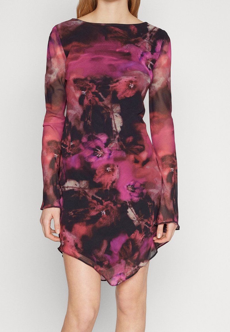 Robe longue à manches longues avec un motif floral, présentant une base foncée avec des teintes roses et violettes, un décolleté bateau et un ourlet asymétrique pour une silhouette moderne.
