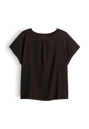 Blouse noire texturée à manches courtes avec un col rond et de légers plis sous le col.