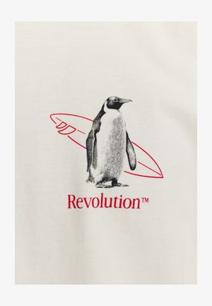 Crème t-shirt met een zwart-wit pinguïn grafiek met een rode surfplank omtrek erboven en de tekst "Revolution™" in het rood eronder.