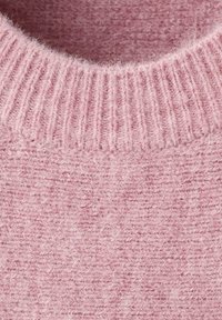 Tissu de pull en tricot rose clair, présentant un col côtelé et une surface douce et texturée avec un aspect duveteux.
