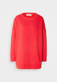 Sweat-shirt rouge à manches longues avec col rond, coupe décontractée et logo discret près de l'ourlet inférieur sur un fond blanc uni.