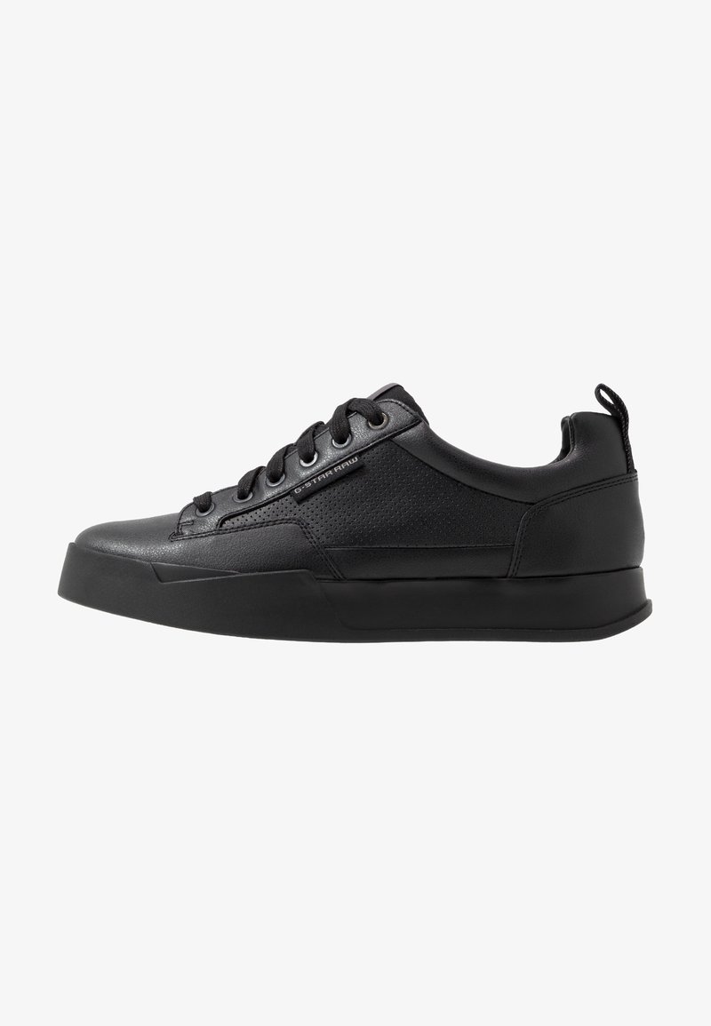 Baskets basses noires avec fermeture à lacets à l'avant, panneau latéral texturé, semelle épaisse, languette à l'arrière et étiquette "G-STAR RAW" sur le côté.