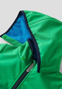 Veste à capuche verte avec doublure en polaire bleue et bordure noire, dotée d'une fermeture éclair et de boutons-pression sur le col et la capuche.