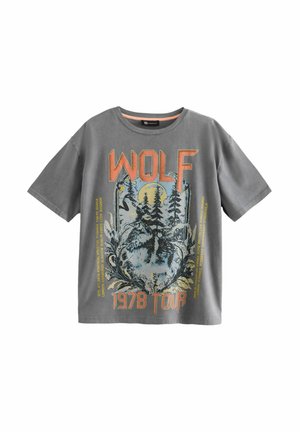 Szürke pamut póló, amelyen egy farkas és fák grafikai nyomata látható, narancssárga és kék szöveggel, amely azt mondja: "WOLF 1978 TOUR". Rövid ujjak.