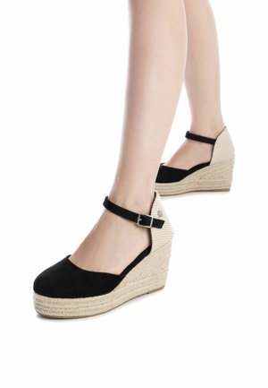 Zapatos de cuña de ante negro con correa en el tobillo, que cuentan con una plataforma de yute tejido y acentos en el talón de color beige texturizado.