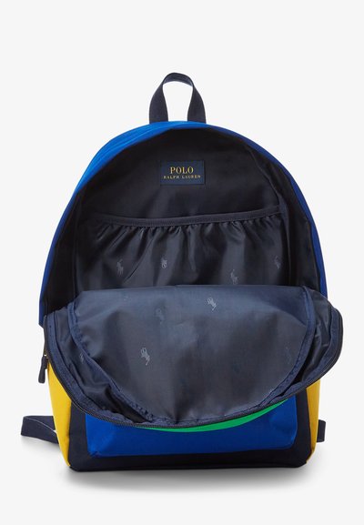 Sac à dos avec des panneaux bleus et jaunes. Comprend un compartiment principal avec un intérieur sombre, une poche élastique et le logo Polo Ralph Lauren.