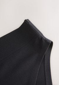 Svart tygmidjeband med en slät struktur och elastisk avslutning, med rena sömmar och en strukturerad design. Inga ytterligare detaljer eller mönster.