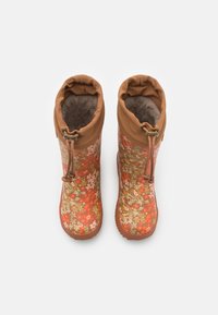Bottes en caoutchouc marron taille enfant avec motif floral orange et vert, doublure en fourrure et fermetures à cordon réglable en haut.