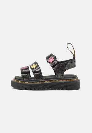 Sort platformsandal med tre glitrende remme, hver dekoreret med farverige blomster og en træksløjfe ved hælen.