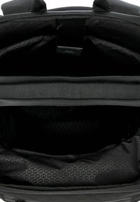 Interior de mochila negra con una textura suave, múltiples compartimentos y un forro con patrón hexagonal. Con cierre superior de cremallera.