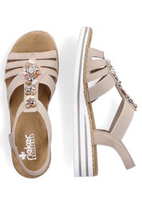 Sandali beige con suola in sughero, dettagli a motivo e pietre decorative. Design open-toe con più cinturini e tacco a zeppa.