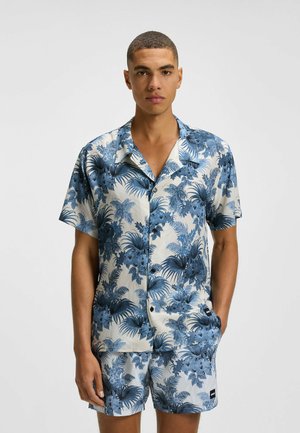 Short-sleeve button-up shirt with a blue floral pattern on a cream background. Paired with matching shorts, both made of lightweight fabric.