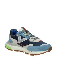 Sneaker multicolore che presenta una combinazione di suede blu, tessuto blu navy, accenti riflettenti, suola testurizzata e lacci di colori vivaci.