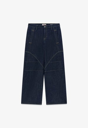 Dunkelblaue Denim-Hosen mit weitem Bein, versehen mit kontrastierendem gelbem Stich, zwei Fronttaschen und einem Logo-Patch am Bund.