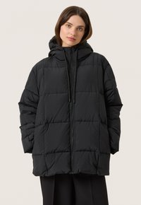Svart puffjacka med huva, med ett quiltat mönster, framzipper och elastiska manschetter för värme och komfort. Slät textur.