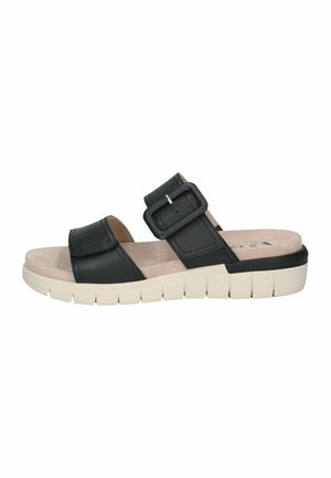 Sandales mules en cuir noir avec une large bride et une boucle ajustable, semelle intérieure beige rembourrée et semelle extérieure blanche rainurée pour une meilleure adhérence.