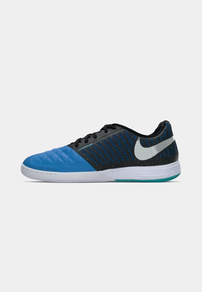 Blå och svarta sportskor med en texturerad, vadderad överdel, som har horisontella ränder, en vit Nike-logotyp och en dämpad sula.