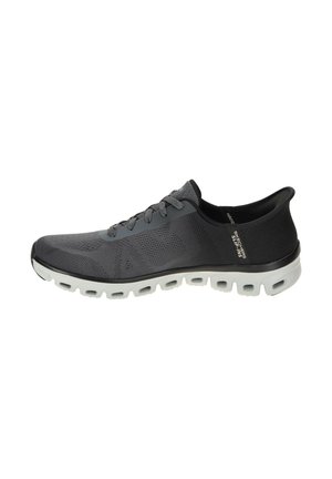 Zapatilla deportiva gris con parte superior de malla texturizada, puntera redonda, diseño con cordones y suela blanca acolchada con acentos perforados.