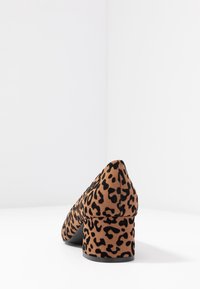 Leopard print high-heeled shoe with a textured tan and black suede upper, featuring a chunky heel and pointed toe design.