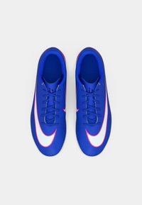 Kék atlétikai cipők párja fehér és rózsaszín Swoosh logókkal, felülnézetből, fehér háttér előtt.