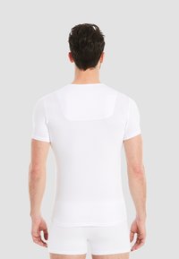 White short-sleeve compression shirt, form-fitting design, smooth texture, with a rectangular back panel and subtle stitching details.