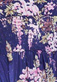 Bloemenjurk met een geplooide taille, diep marineblauwe achtergrond met roze en groene bloemenpatronen, en een subtiele textuur met een lichte glans.