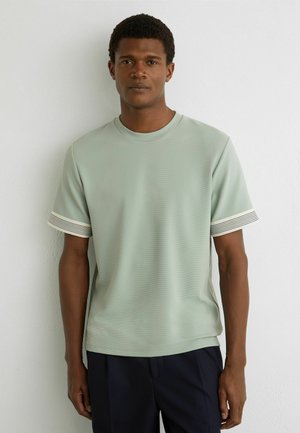 Lichtgroen T-shirt met korte mouwen en een gestructureerd patroon, met witte en marineblauwe gestreepte accenten op de boorden, ronde halslijn.