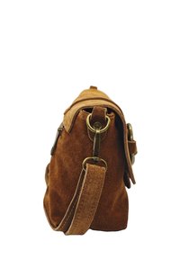 Sac à main en suede brun avec une fermeture éclair supérieure, une sangle en cuir ajustable et des accents en laiton. Compact, texture douce et forme arrondie.