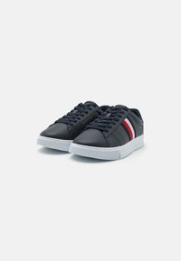 Sneakers in ecopelle blu navy con suole in gomma bianche e sottili strisce rosse e bianche sui lati. Punta arrotondata e design con lacci.