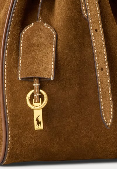 Brown suede handbag with white stitching, leather trim, and a gold keyring featuring a polo player emblem.