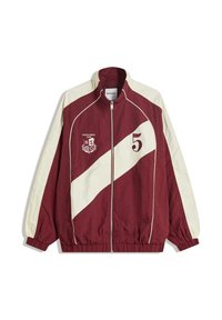 Bordo in kremna zip-up jakna z visokim ovratnikom, elastičnimi manšetami in robom. Ima diagonalen trakasti vzorec in besedilne podrobnosti.