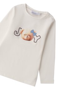 Weißes Langarmshirt mit einem Teddybär-Graphic und dem Wort "JOY" in funkelschrift. Mit einer blauen Schleife auf dem Kopf des Bären.