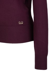 Bordeauxfarbenes Strickpullover mit geripptem Saum und Bündchen. Enthält ein kleines goldenes Logo-Tag mit den Aufschriften "V" und "1969" unten links.