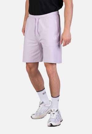 Lila katoenen shorts met een verstelbare tailleband, zijzakken en een wit logo op het linkerbeen, gecombineerd met witte sokken en sneakers.