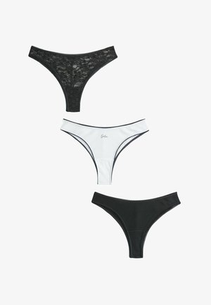 Kolmet naisten stringit, yksi mustaa pitsiä, yksi valkoinen mustalla reunuksella ja tekstillä, yksi yksivärinen musta ribbineuloksella, järjestetty pystysuoraan valkoisella taustalla.