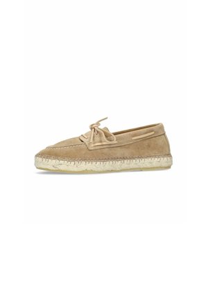 Chaussure mocassin en daim beige avec un nœud en lacets et une semelle en jute tressée, vue de côté sur fond blanc.