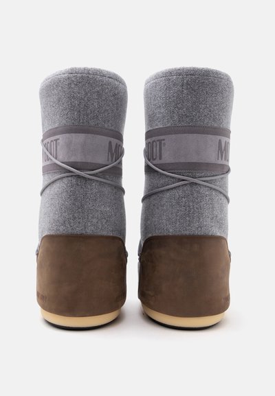 Paire de bottes d'hiver en feutre gris et cuir marron vues de dos avec des lacets croisés et une large bande grise autour de la cheville.