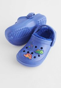 Modré dětské dřeváky s chlupatým vnitřkem, zdobené třemi barevnými dinosaurími dekoracemi a několika ventilačními otvory.